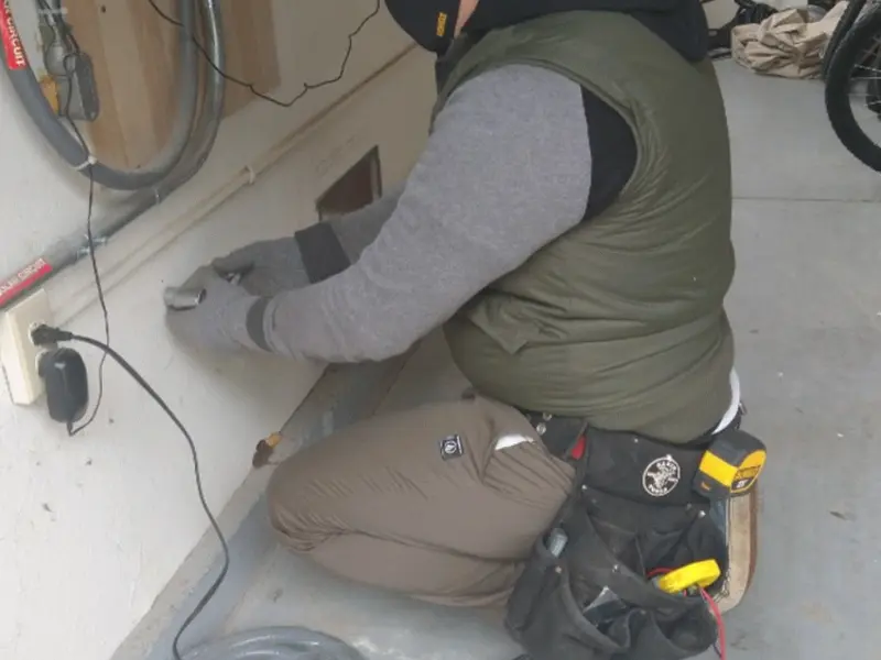 Electrician performing outlet wiring in a Lyons garage